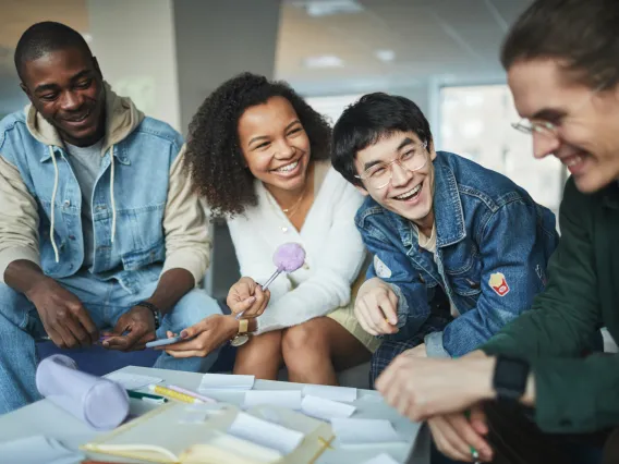 group of people sitting around a table and laughing