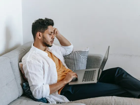 person sitting on a couch using a laptop