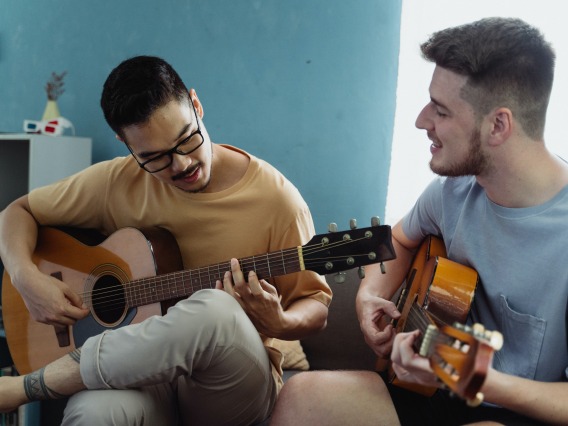two people playing guitar