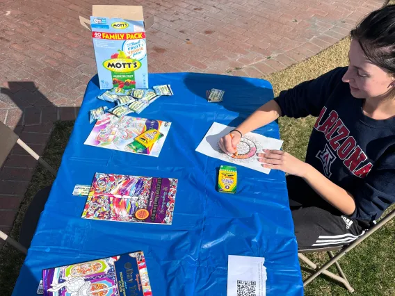 person sitting at a table and drawing