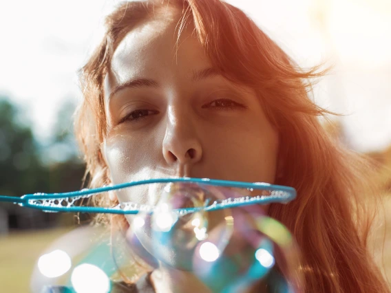 person blowing bubbles with a bubble wand