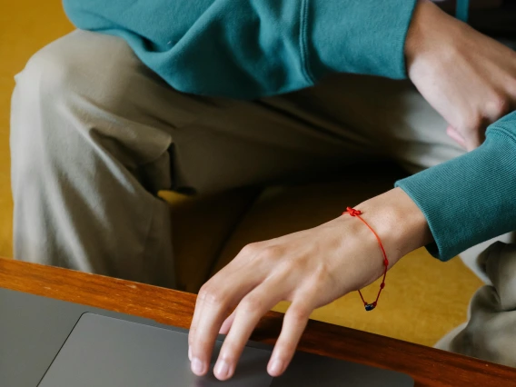 close-up of person using a laptop computer cropped to show hands, arms, and torso