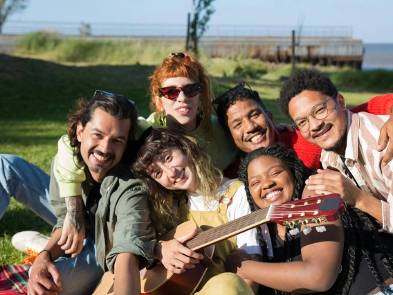 group of friends sitting outside and smiling at the camera