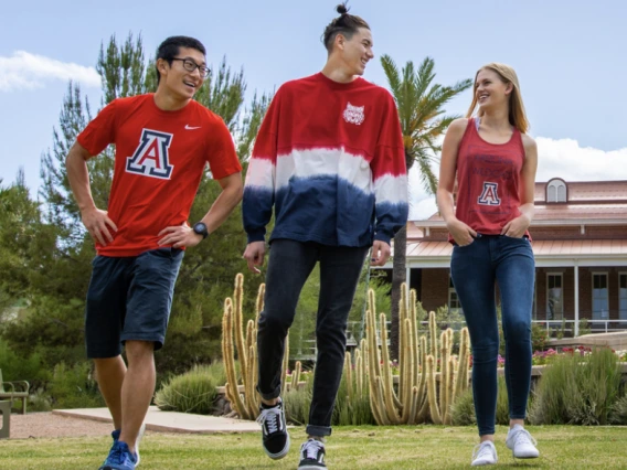 group of students wearing red and blue walking on a college campus