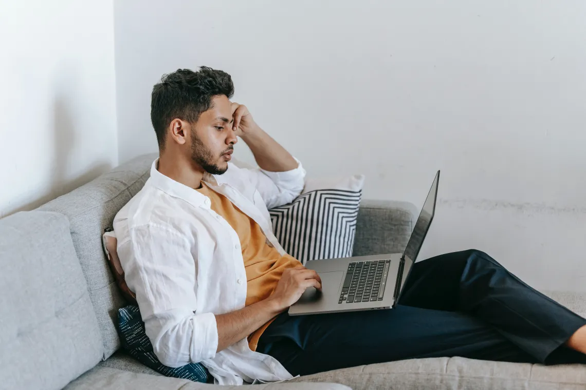 person sitting on a couch using a laptop