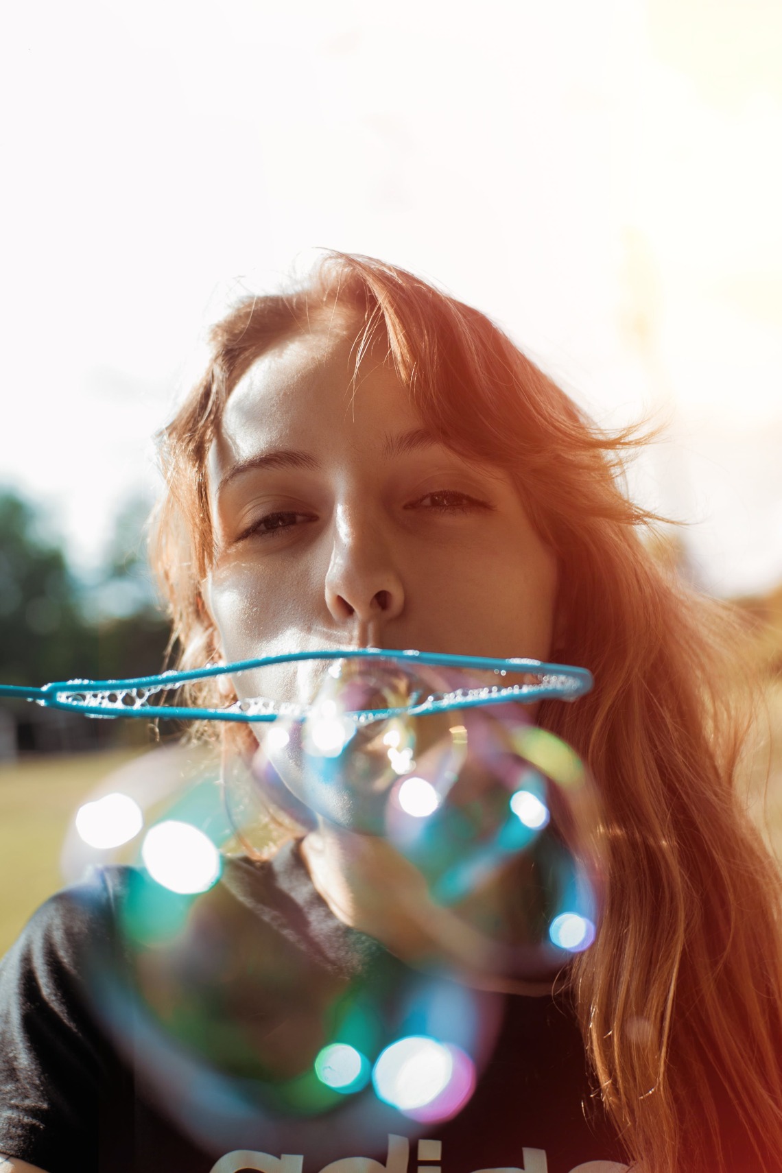 person blowing bubbles with a bubble wand