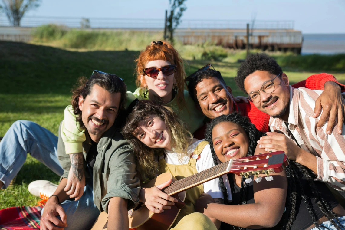 group of friends sitting outside and smiling at the camera