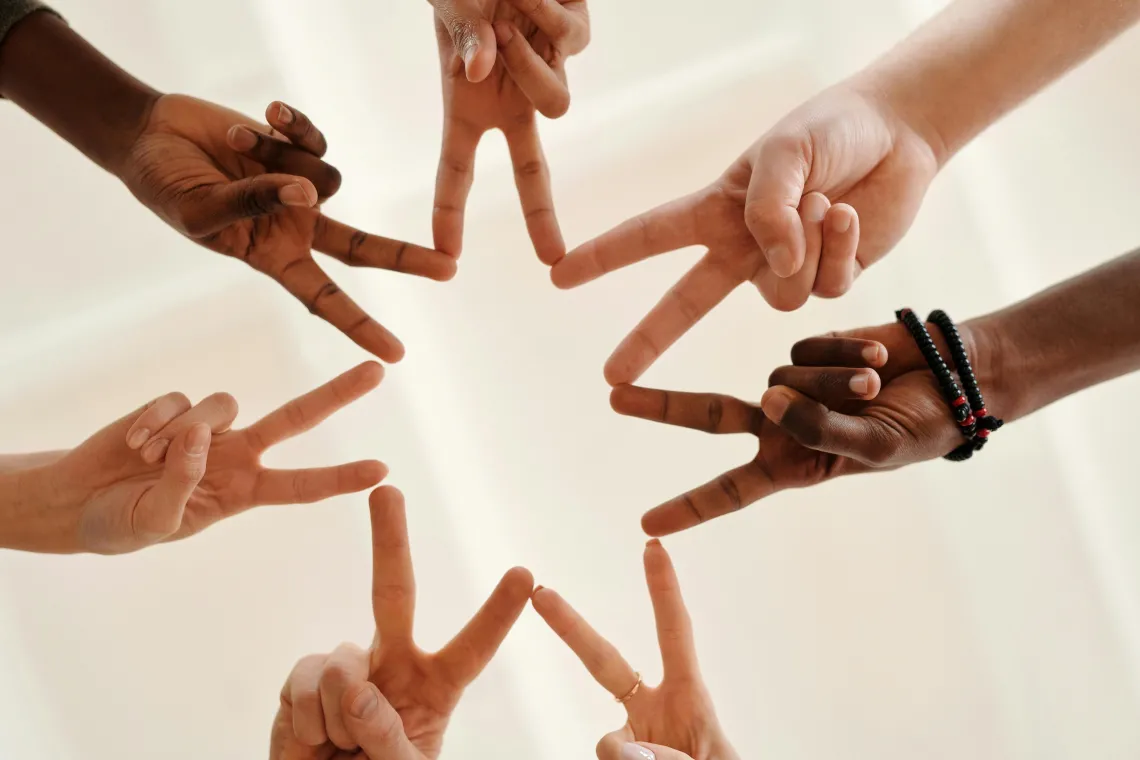 a close up of hands arranged in a circle with fingers touching