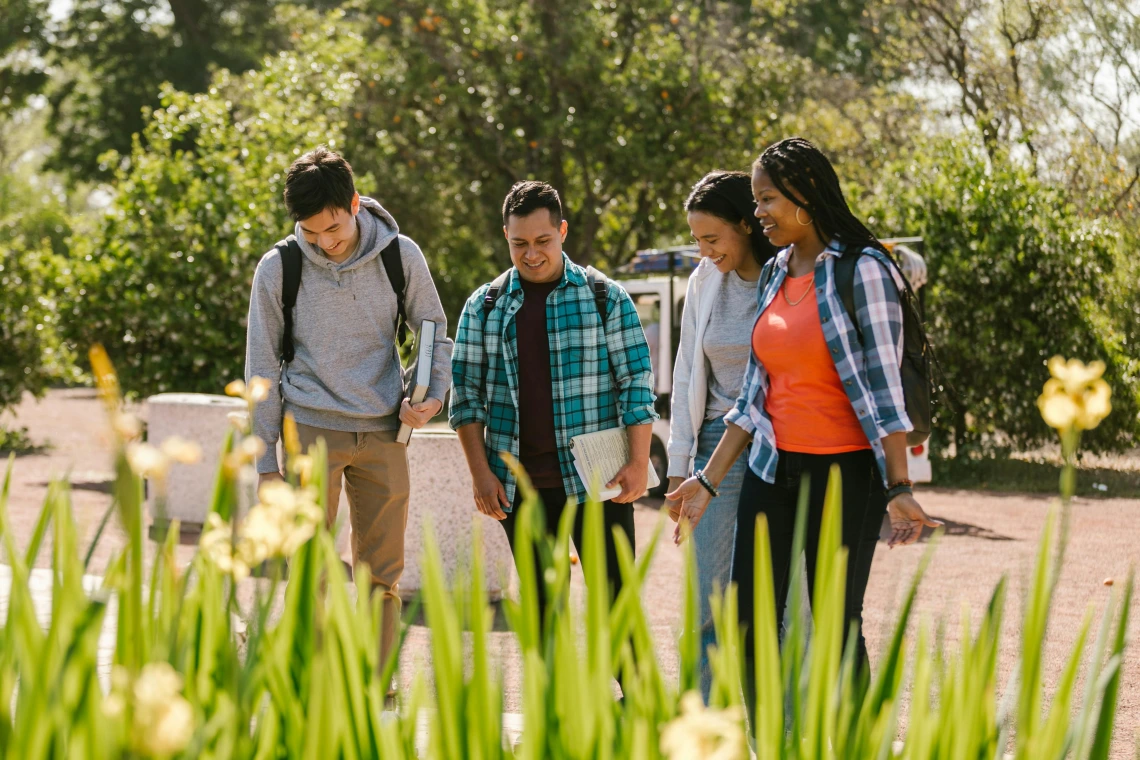 group of people walking outdoors wearing backpacks