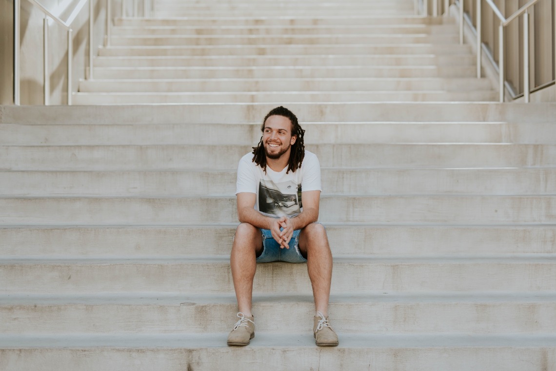 man sitting on the steps to a building