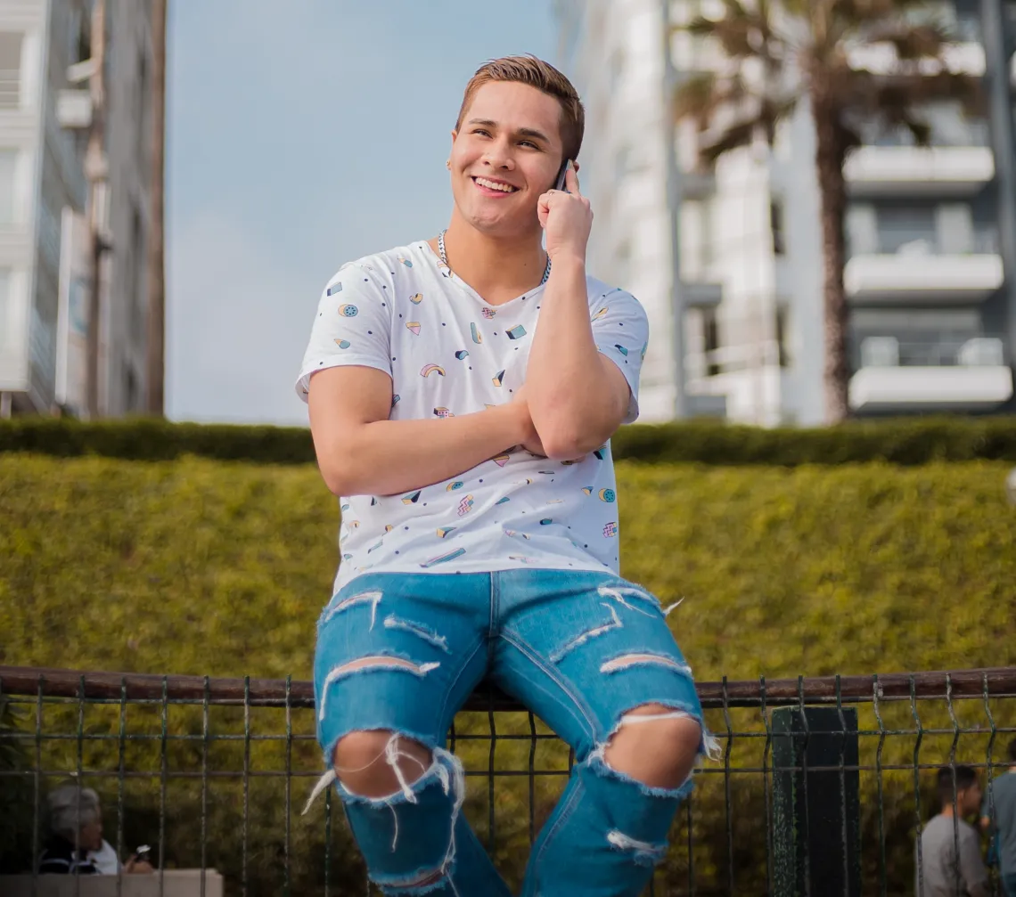 photo of a man sitting on a bench talking on a phone