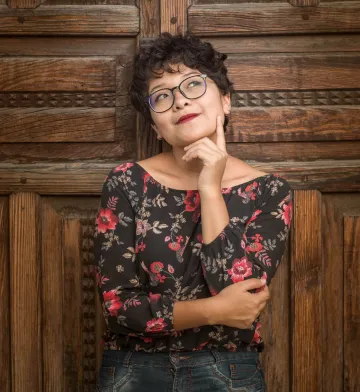 photo of a woman wearing glasses touching her face and looking up