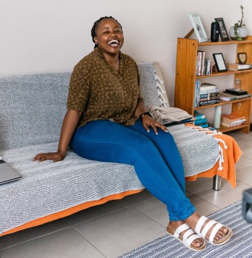 photo of a woman sitting on a couch and smiling